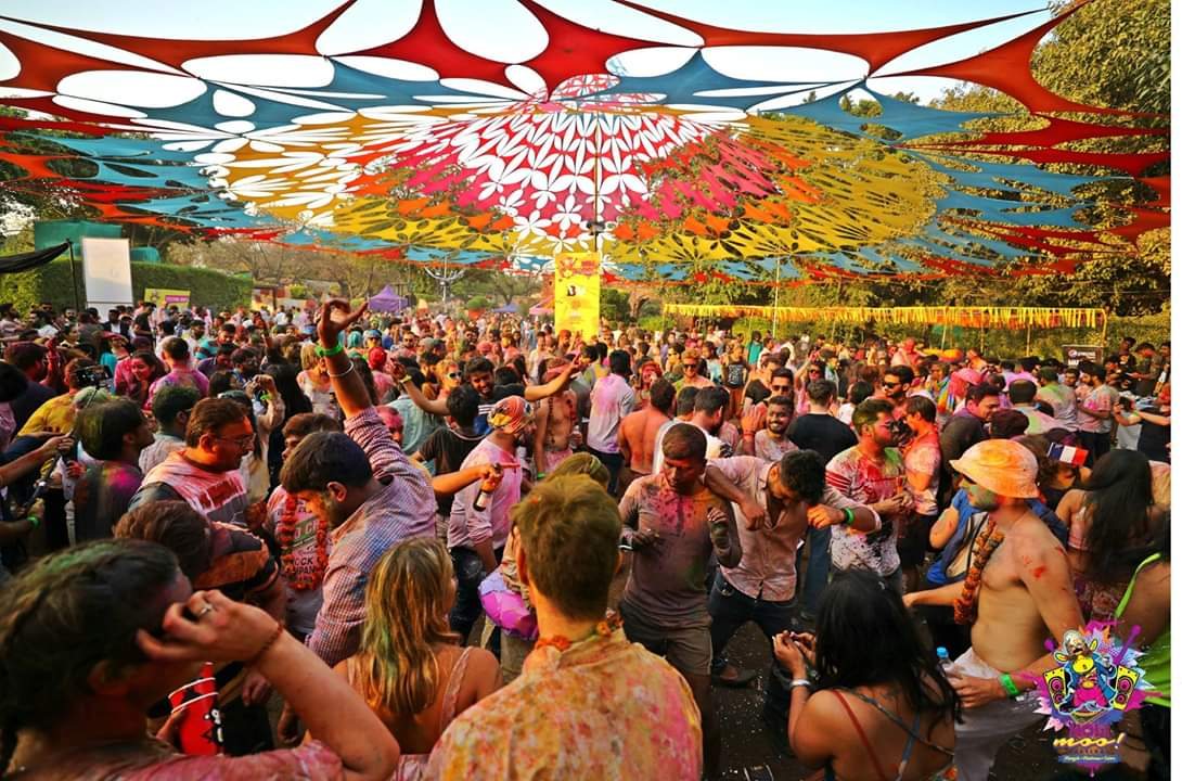 Colourful daytime festival crowd under a canopy of decorative streamers