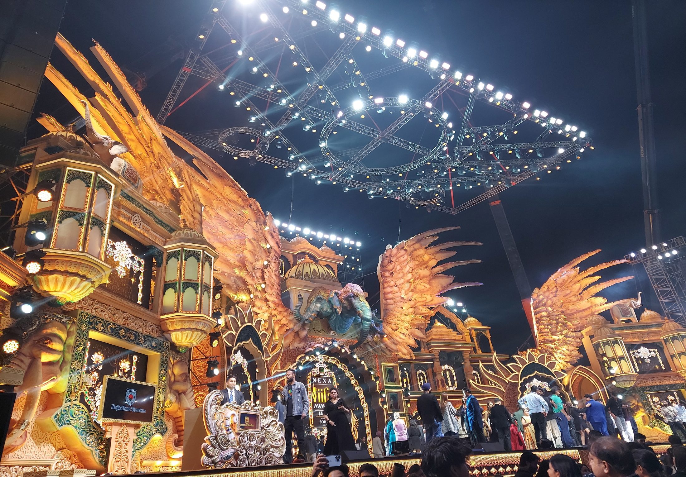 Grand illuminated award-show stage build at the IIFA Awards with ornate golden set pieces and an overhead lighting rig