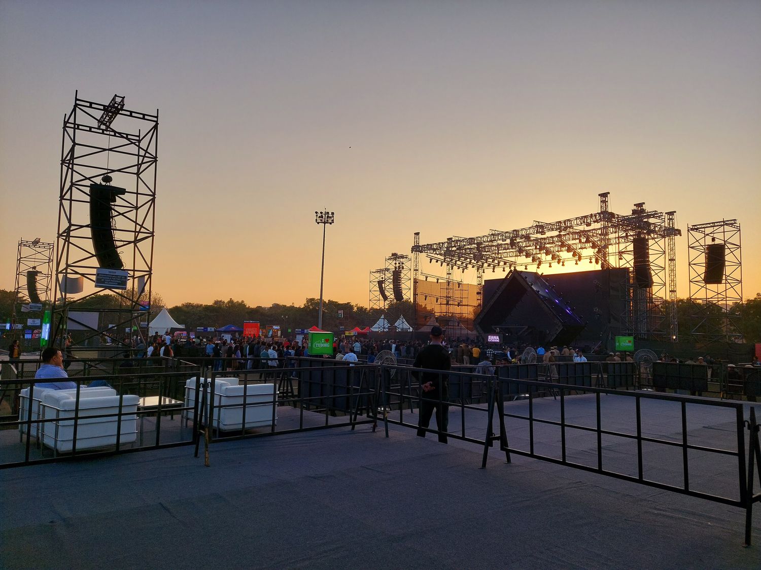 Free-standing sound tower rig positioned in front of a concert stage at dusk