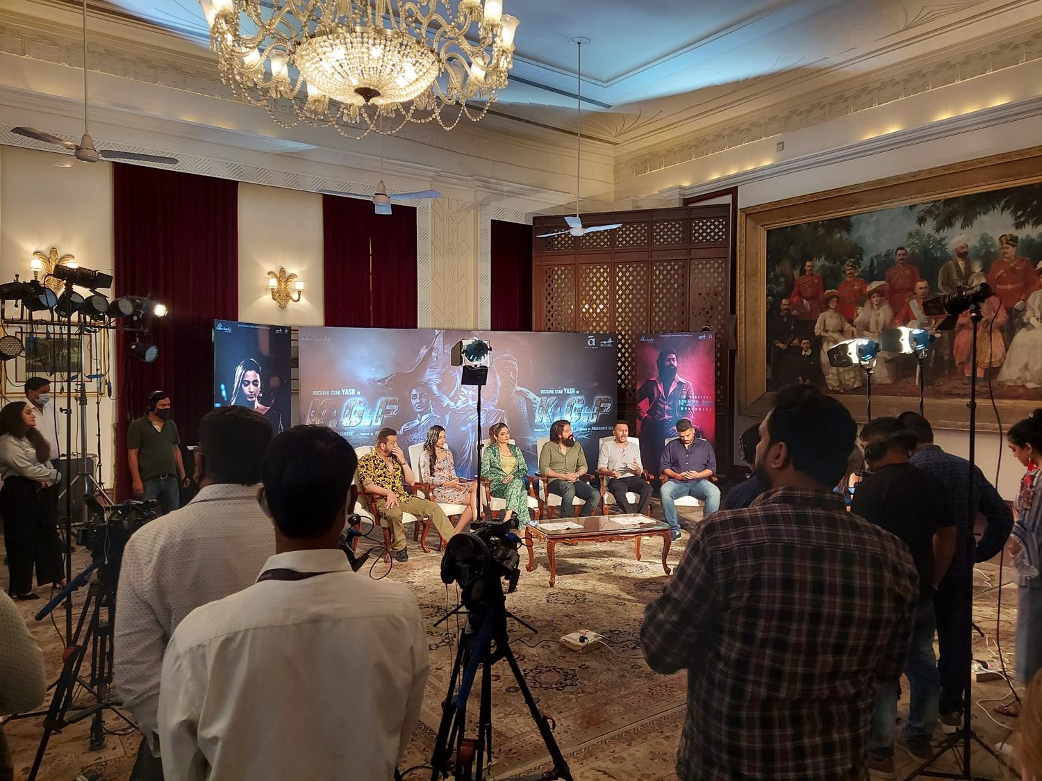 Indoor ballroom set with chandeliers and a lit stage for a shoot