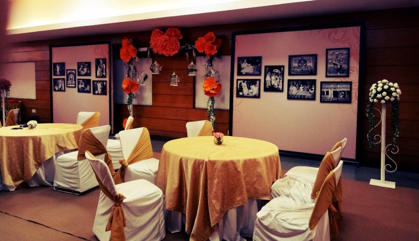 Decorated indoor event stage with framed photo wall and floral accents