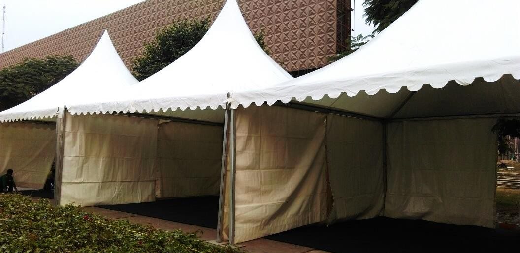 Row of white peaked German marquee tents set up on a garden lawn