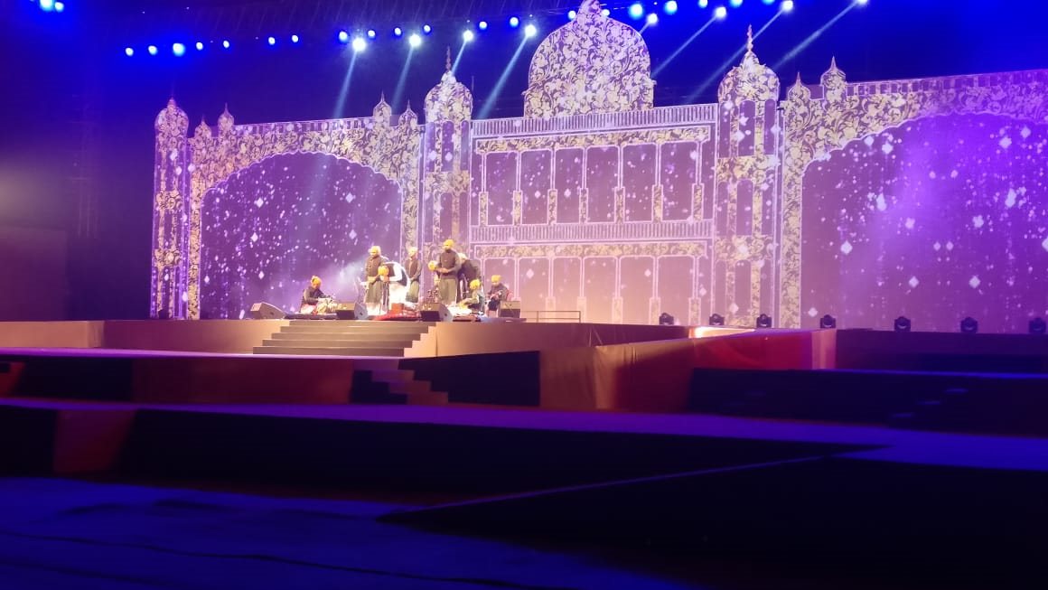 Ornate illuminated palace-style wedding stage set glowing in white and violet light